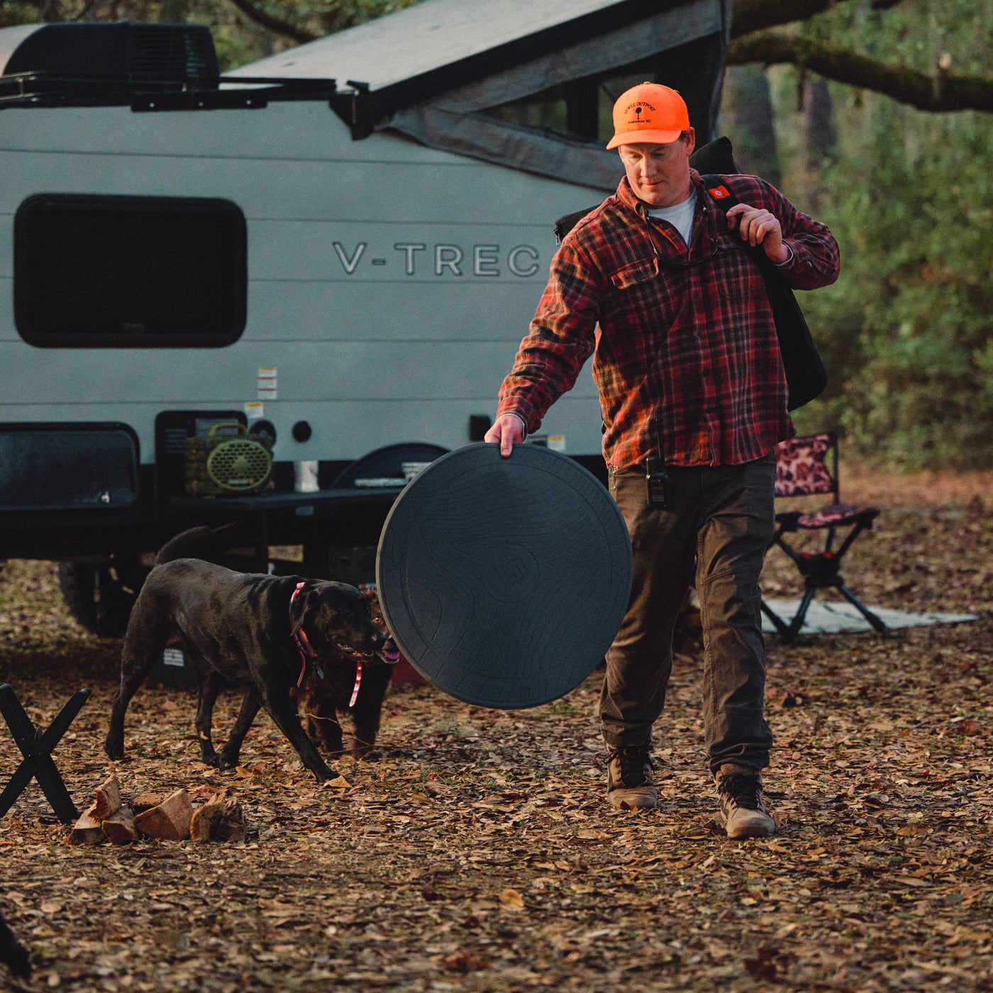 Round outdoor surface guard carried outside near a dog and grill