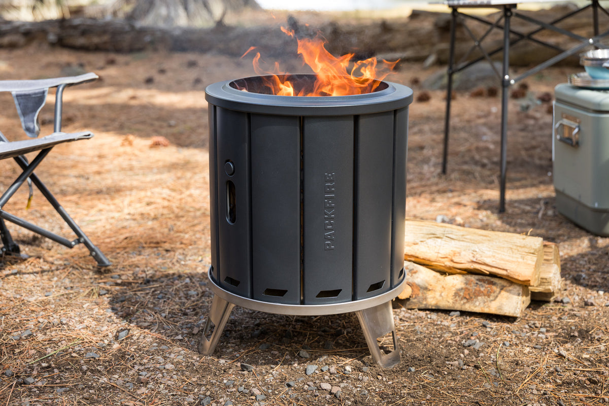Black portable fire pit with flames in an outdoor setting