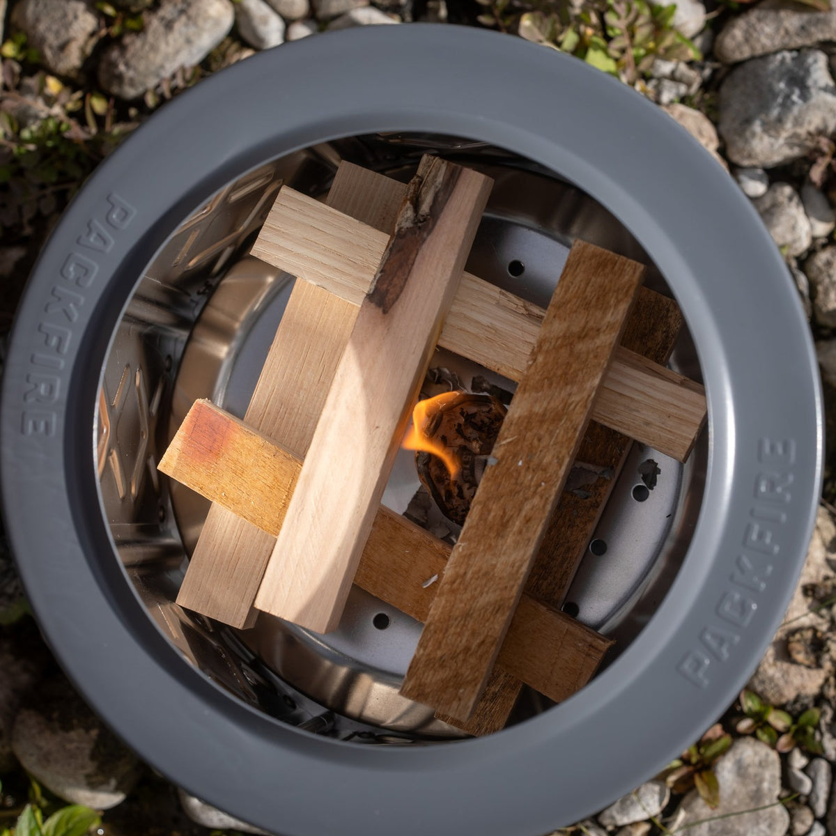 Top-down view of ClearBurn Tabletop Firewood sticks stacked and catching flame inside the Ember fire pit